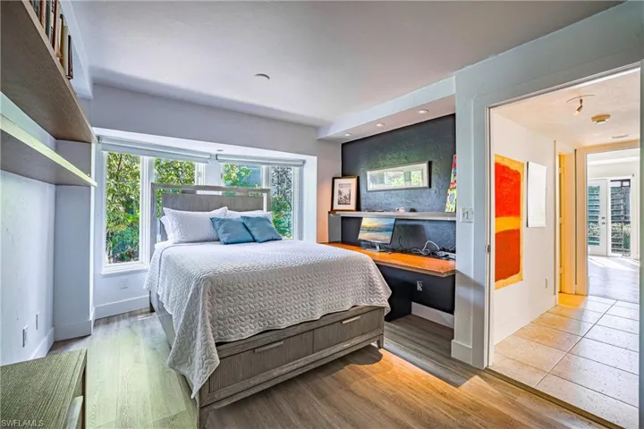 Bedroom with light wood-type flooring and an office area