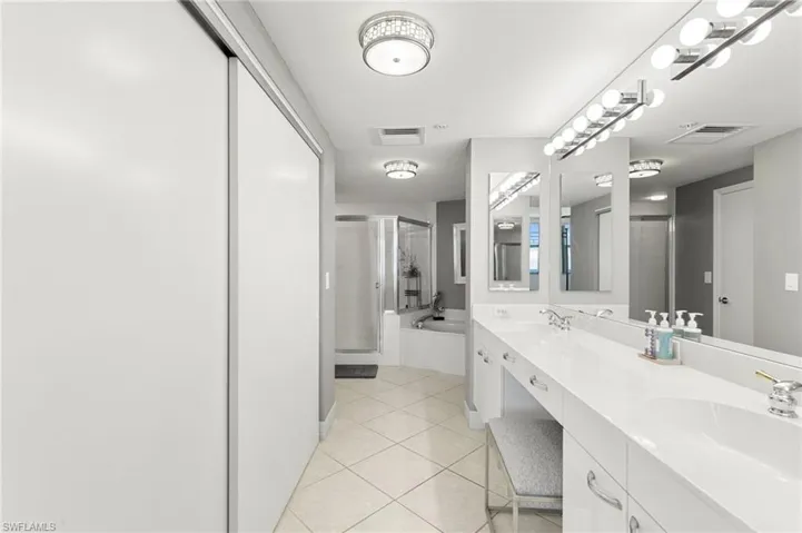 Bathroom with double sink vanity, plus walk in shower, and tile patterned flooring