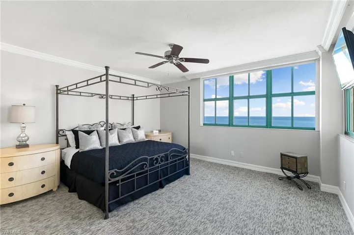 Bedroom featuring ceiling fan, ornamental molding, carpet floors, and multiple windows