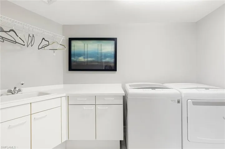 Laundry room with cabinets, sink, and separate washer and dryer