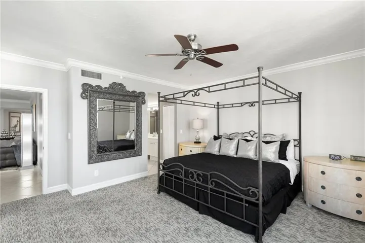 Bedroom featuring ceiling fan, crown molding, ensuite bathroom, and tile patterned flooring