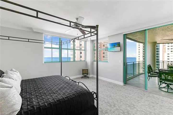 Carpeted bedroom featuring ceiling fan, ornamental molding, and access to exterior