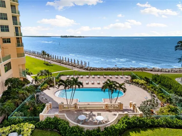 View of swimming pool with a patio area and a water view