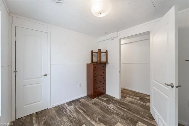 Bedroom with wood finished floors and a closet