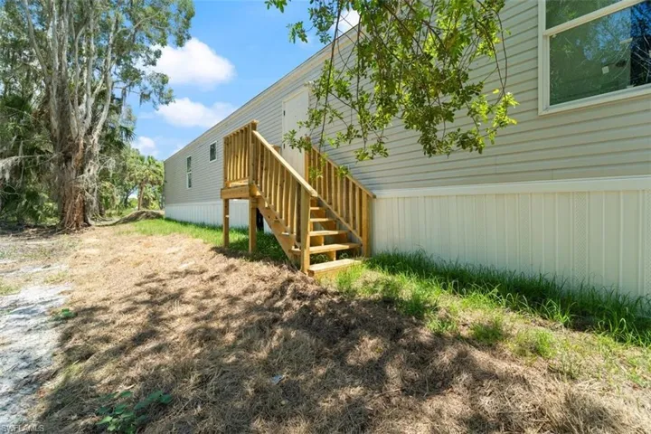 View of home's exterior featuring stairway and a wooden deck