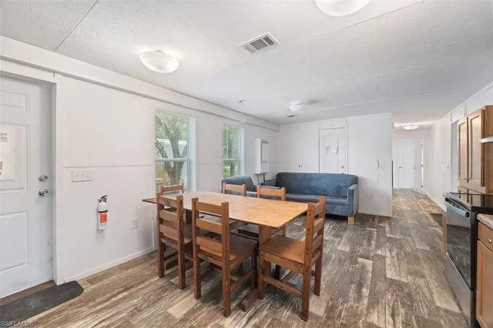 Dining area featuring dark wood-style floors, a textured ceiling, and baseboards