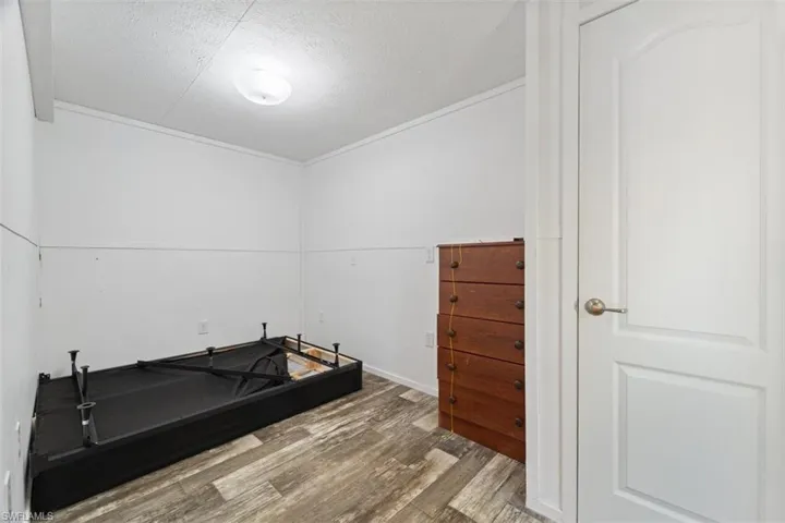 Exercise room featuring wood finished floors and a textured ceiling