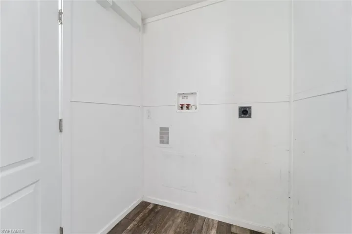 Laundry room featuring hookup for an electric dryer, hookup for a washing machine, dark wood-style floors, and baseboards