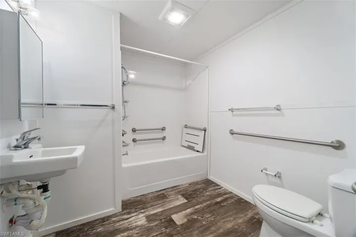 Full bathroom featuring toilet, wood finished floors, and bathtub / shower combination