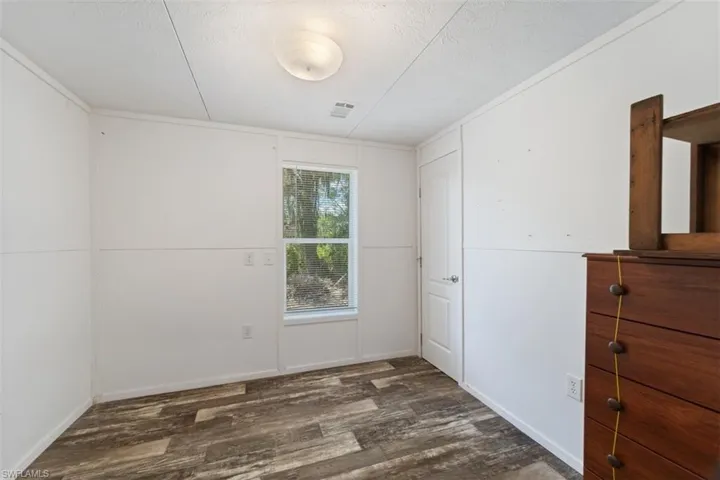 Unfurnished bedroom with wood finished floors and a textured ceiling