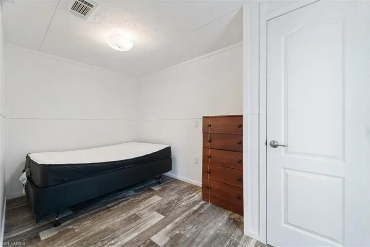 Bedroom with wood finished floors and a textured ceiling