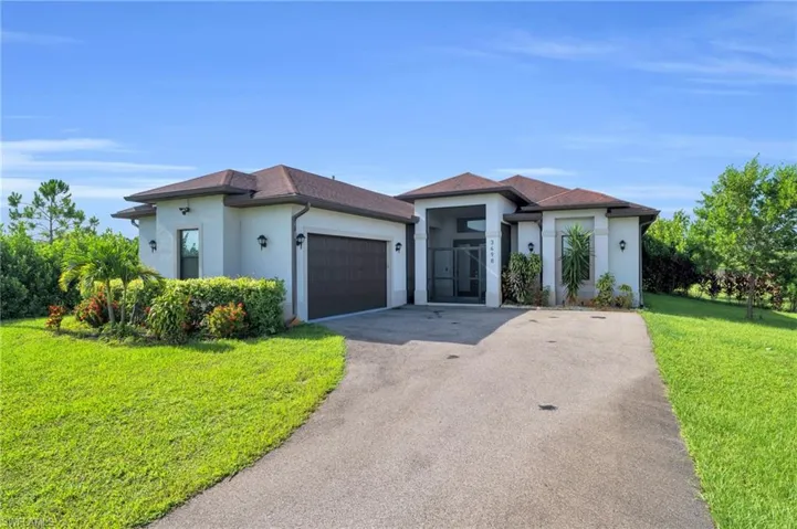 View of front facade featuring a garage and a front yard