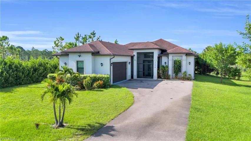 View of front of home with a garage and a front lawn