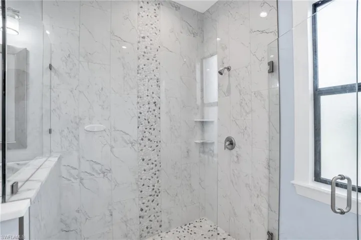 Bathroom featuring a wealth of natural light and an enclosed shower