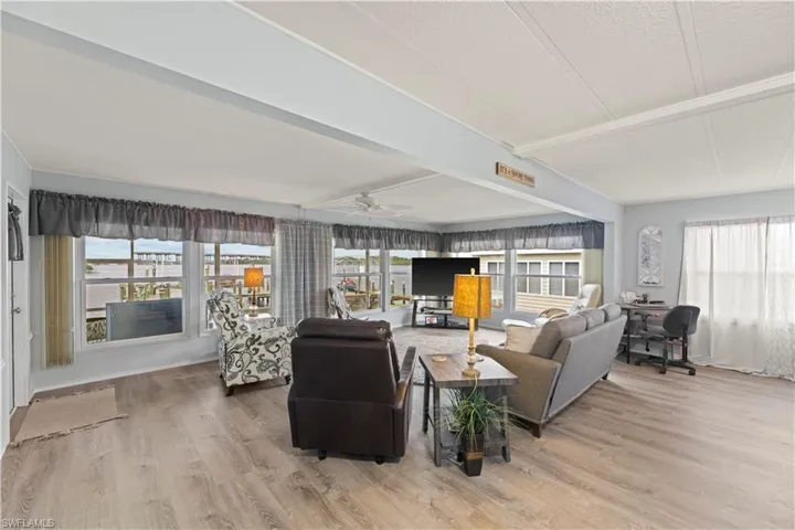 Living room featuring plenty of natural light, ceiling fan, and vinyl floors