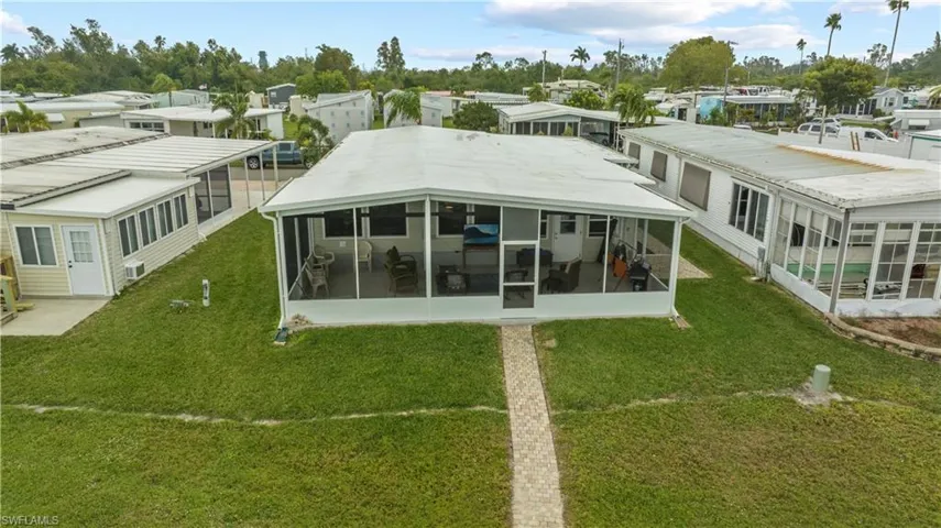 Back of house with a sunroom and a yard