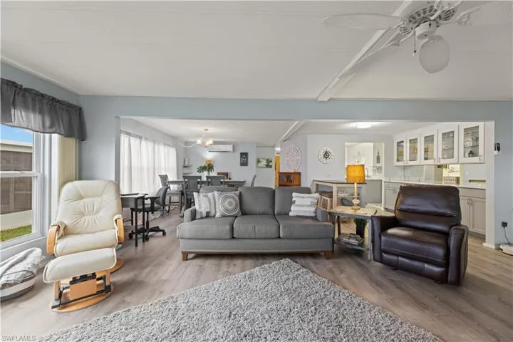 Living room featuring hardwood / wood-style floors, a wealth of natural light, and a wall mounted AC