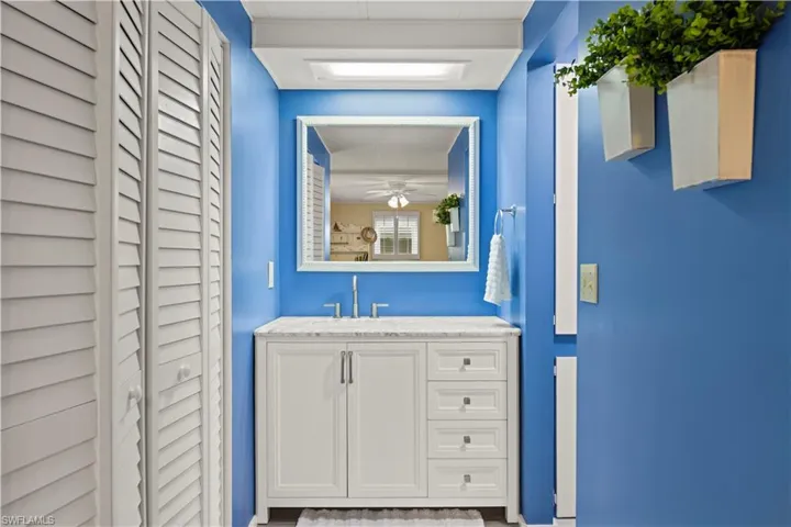 Bathroom featuring wood-type flooring, vanity, and ceiling fan
