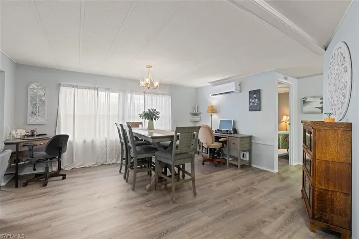 Dining room featuring a chandelier, wood-type flooring, and a wall mounted air conditioner