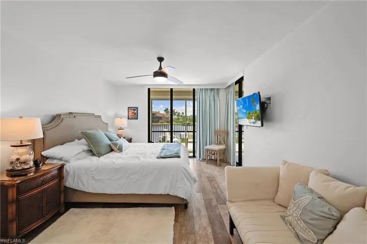 Master Bedroom #2 with access to outside, expansive windows, light wood-type flooring, and ceiling fan