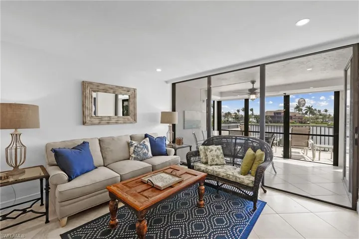 Living room featuring expansive windows, a ceiling fan, recessed lighting, and a water view