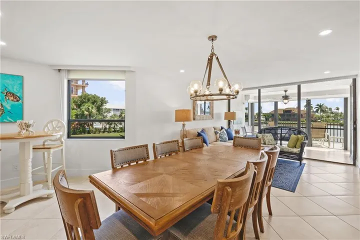 Dining area with a ceiling fan, a chandelier, and light tile patterned floors