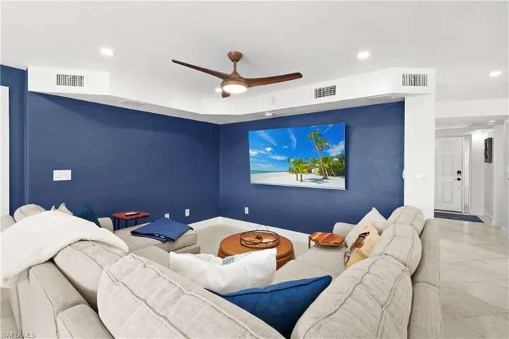 Tiled home theater room featuring ceiling fan and recessed lighting