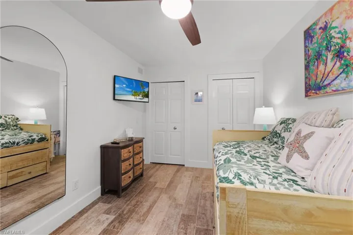 Bedroom #3   featuring two closets, light wood-style floors, and a ceiling fan