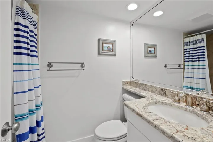 Full bathroom featuring a shower with curtain, vanity, and recessed lighting