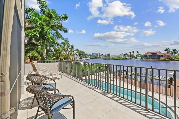Balcony featuring view of pool area, a water view, and a residential view