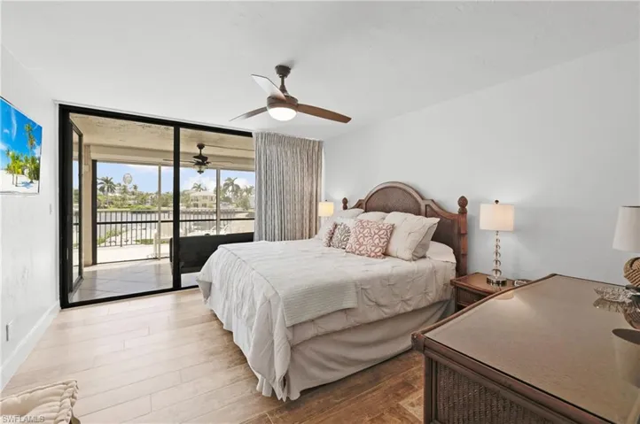Master Bedroom #1 featuring expansive windows, wood-type flooring, access to exterior, and ceiling fan