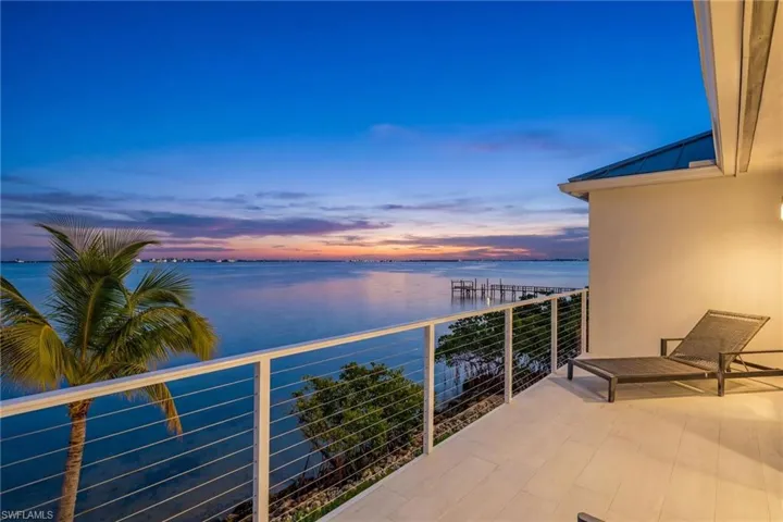Balcony at dusk with a water view and a patio