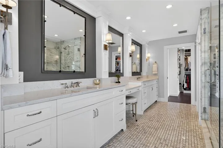 Bathroom with a walk in closet, a marble finish shower, double vanity, and recessed lighting