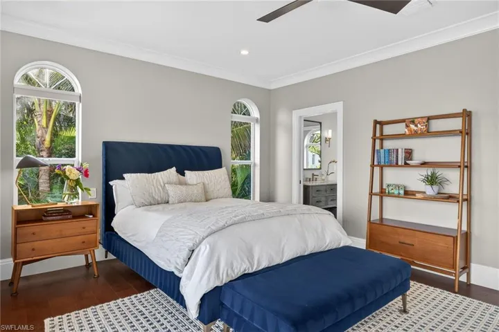 Bedroom with dark wood-style floors, crown molding, ensuite bathroom, a ceiling fan, and recessed lighting