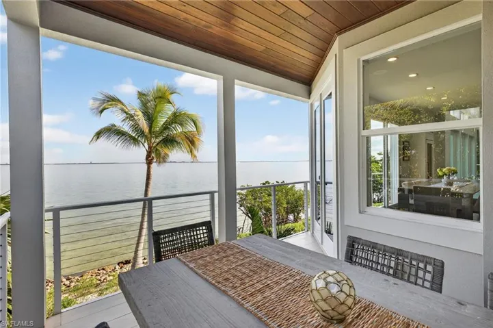 Sunroom with a water view and wood ceiling