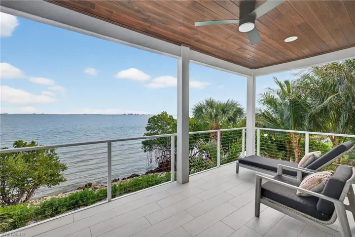 Balcony featuring a water view and ceiling fan