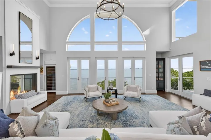 Living area with healthy amount of natural light, wood finished floors, and crown molding