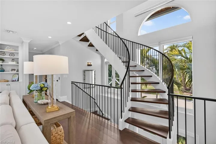 Living room featuring built in features, dark wood-style flooring, recessed lighting, and ornamental molding