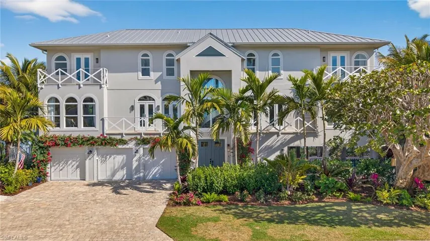 View of front of property with a metal roof, stucco siding, decorative driveway, and a garage