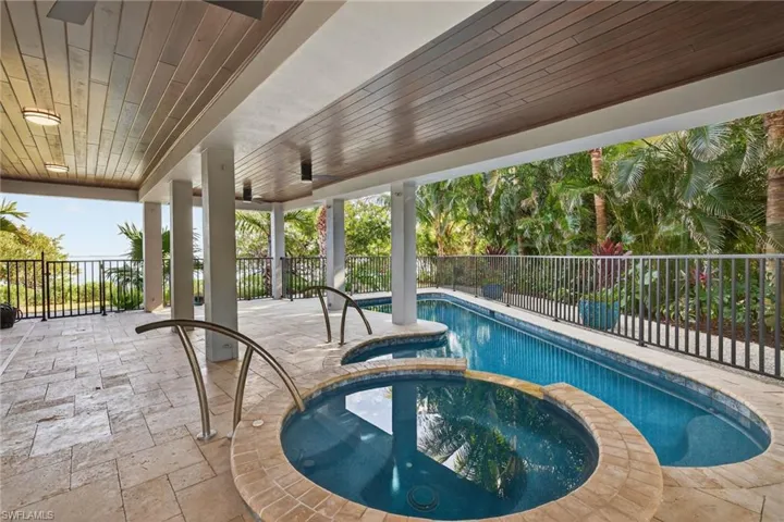 Integrated pool / hot tub with a fenced backyard and a patio area