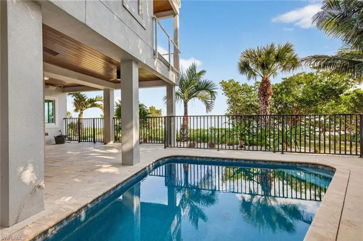 View of pool with patio surround and a balcony