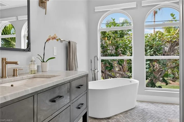 Full bathroom featuring vanity, a freestanding tub, and light tile patterned floors