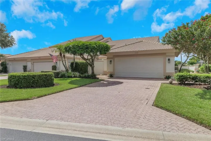 Single story home with stucco siding, a tile roof, decorative driveway, a front yard, and an attached garage