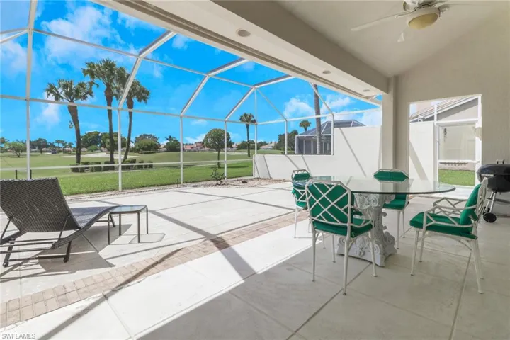 View of patio / terrace featuring glass enclosure, a sunroom, ceiling fan, and outdoor dining area