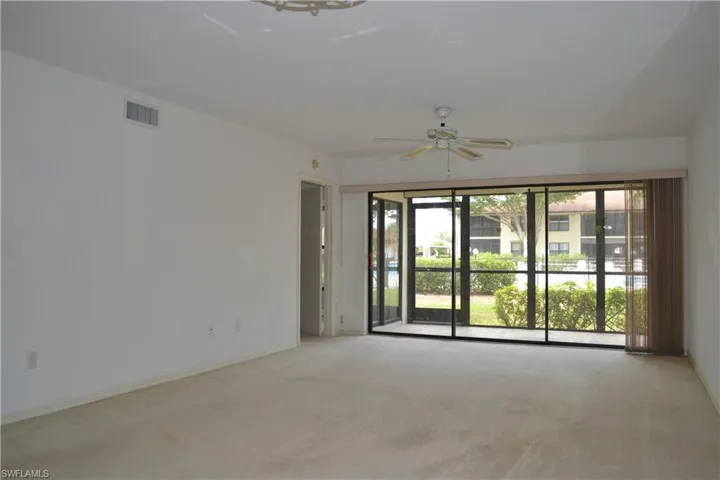 Carpeted spare room featuring a ceiling fan