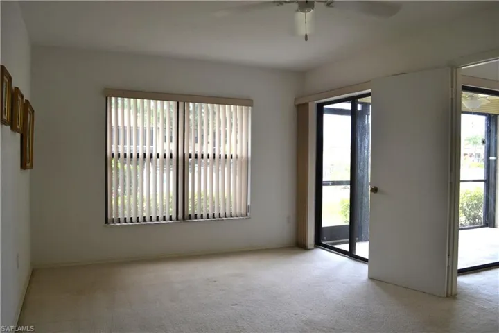 Empty room featuring a ceiling fan and light colored carpet