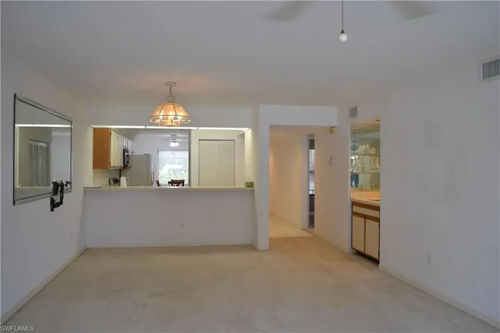 Unfurnished living room featuring light carpet and ceiling fan