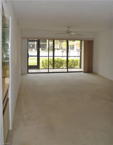 Spare room with light carpet and a ceiling fan