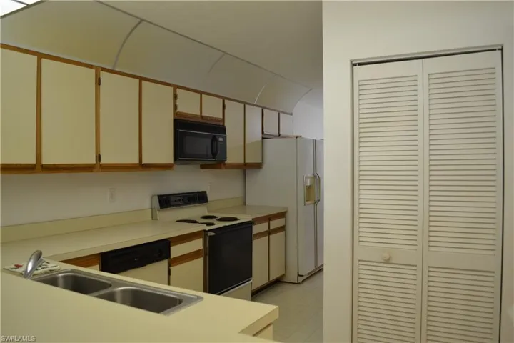 Kitchen featuring white appliances, light countertops, and light floors