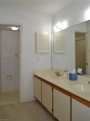 Full bath with double vanity and tile patterned flooring